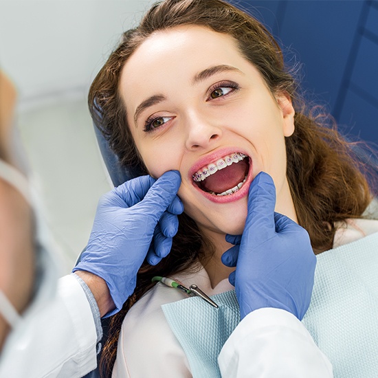 Orthodontist examining woman's braces