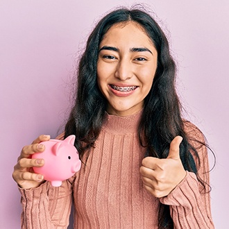 girl with piggy bank and traditional braces in Milford 