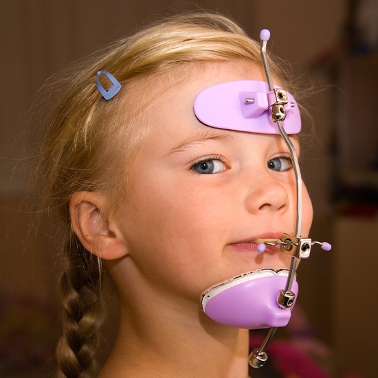 Young girl with headgear dentofacial orthopedics treatment