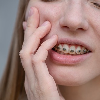 a patient with braces dealing with oral pain