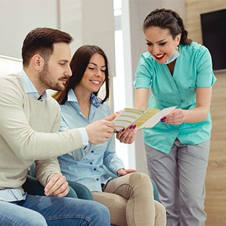 Dental team member handing patients dental insurance information