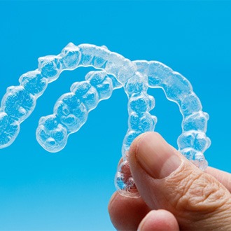  Patient holding up Invisalign in Milford
