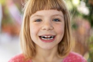 young girl smiles after visiting her Milford pediatric dentist