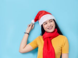 Smiling woman with braces in Milford in Santa hat