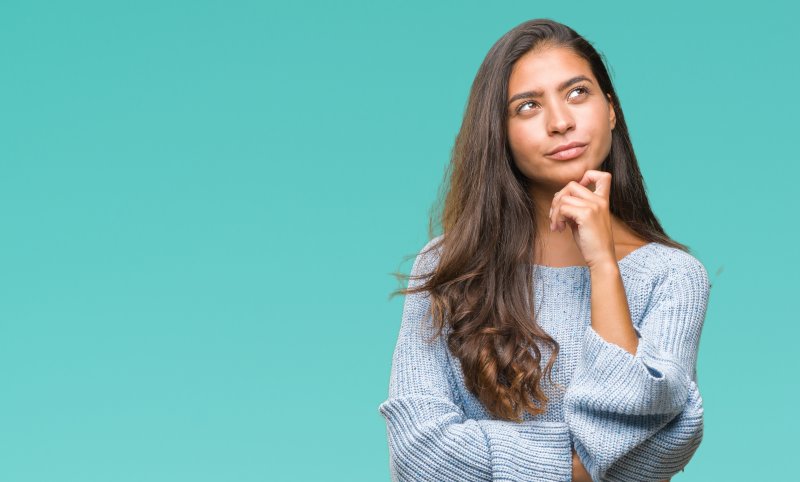 Closeup of woman in blue shirt wondering