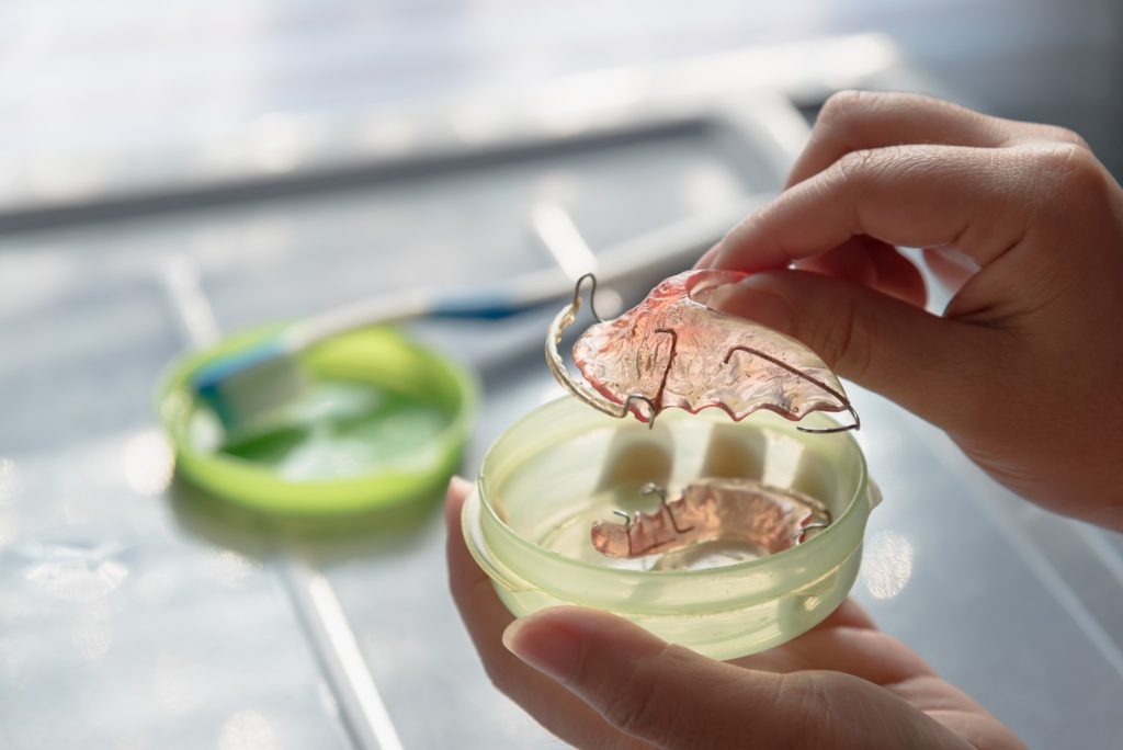 Patient holding dental retainer in case