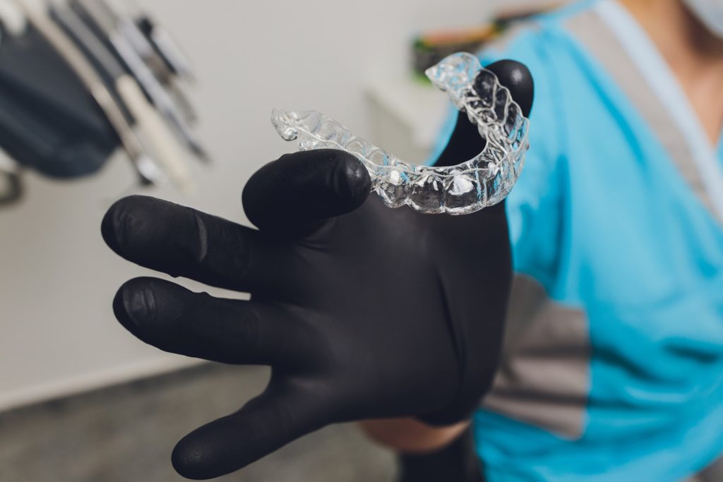 Orthodontist holding up Invisalign aligner