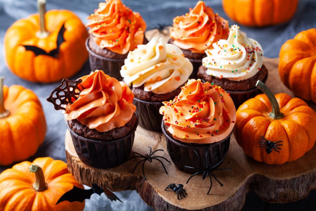 Halloween-themed cupcakes with mini pumpkins
